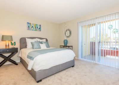 bedroom with sliding glass door at arezzo apartments