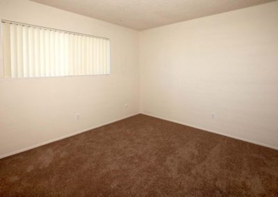 carpeted bedroom and window at the courtyards