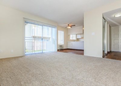 carpeted living area with sliding glass door at la mesa spring gardens