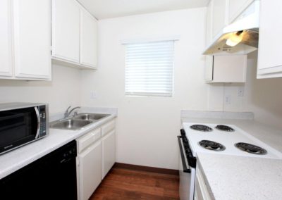 landmark gardens kitchen with stove, dishwasher, and microwave