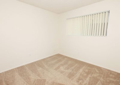 carpeted bedroom with window at lemon gardens