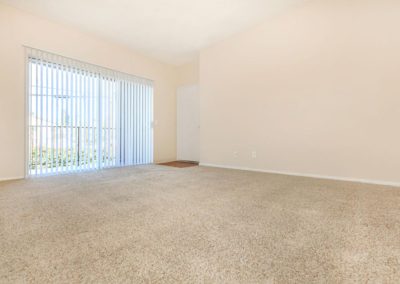 living area with sliding glass door at peppertree gardens apartments